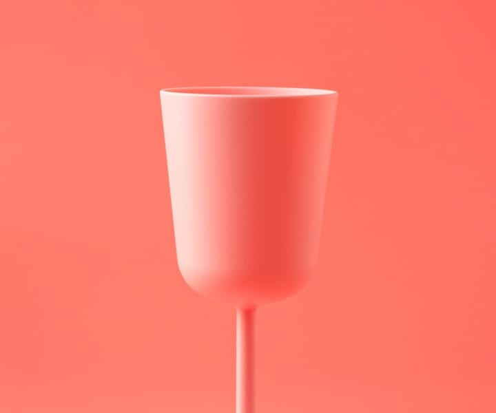 Vibrant pink glass standing out on soft red backdrop, symbolizing brand distinction